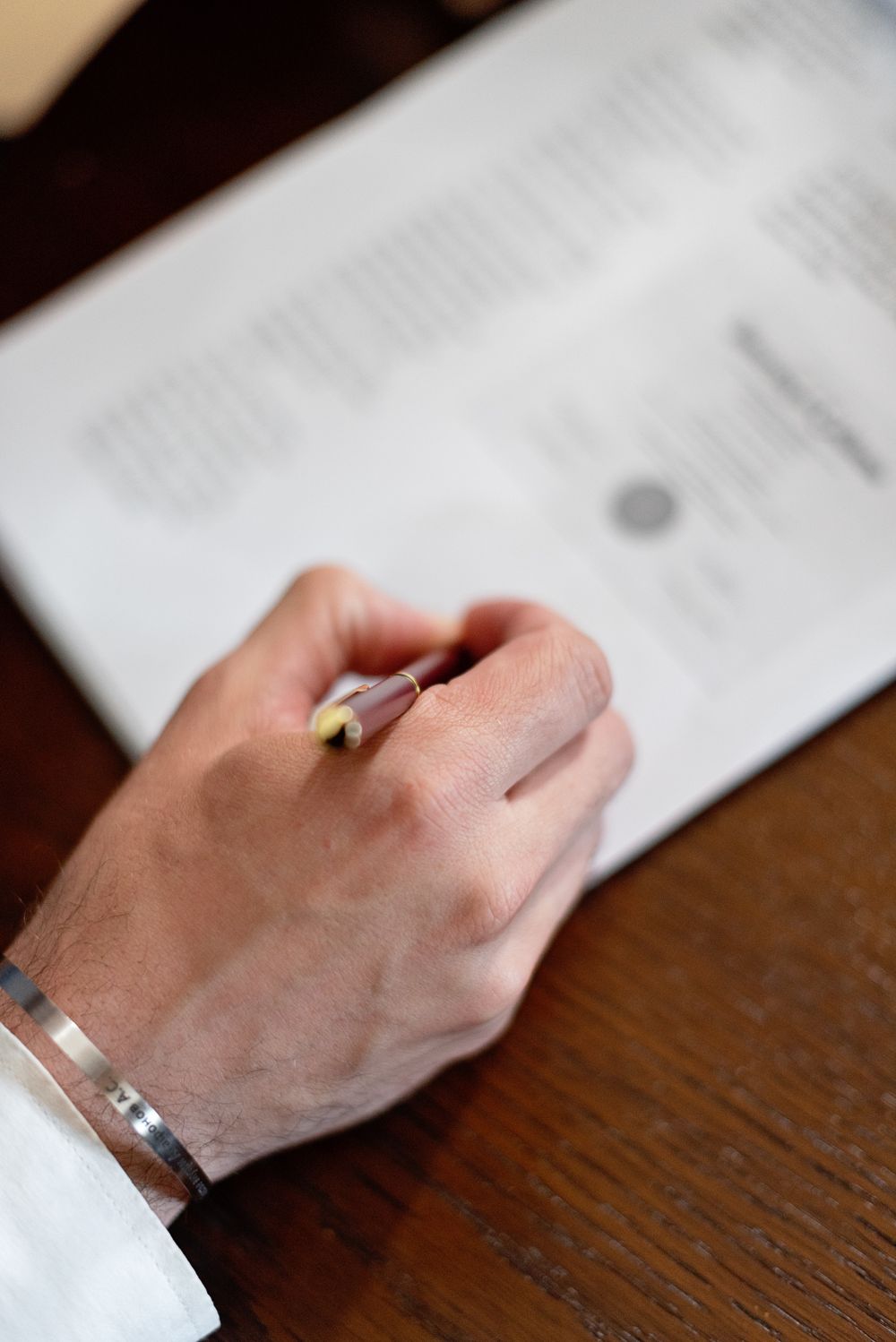 A hand holding a pen over a paper document